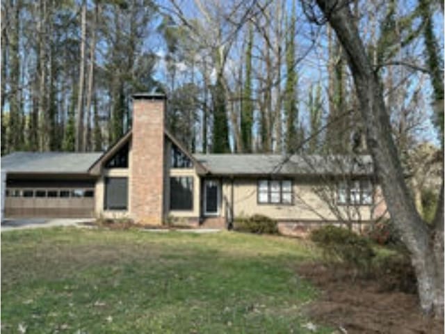 view of front of house featuring a garage and a front lawn