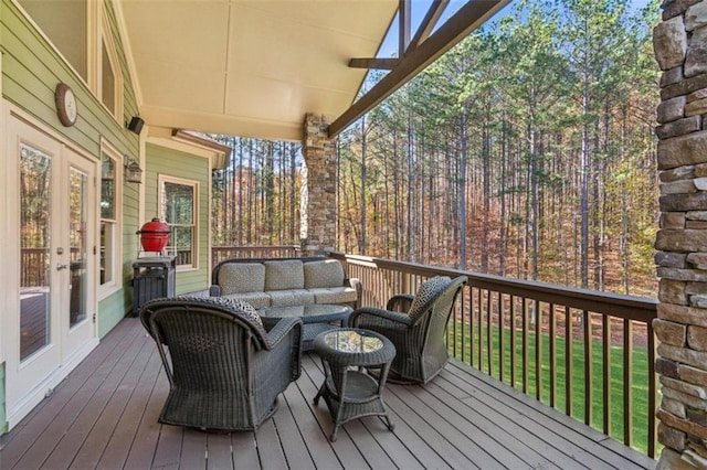 wooden terrace with outdoor lounge area and french doors