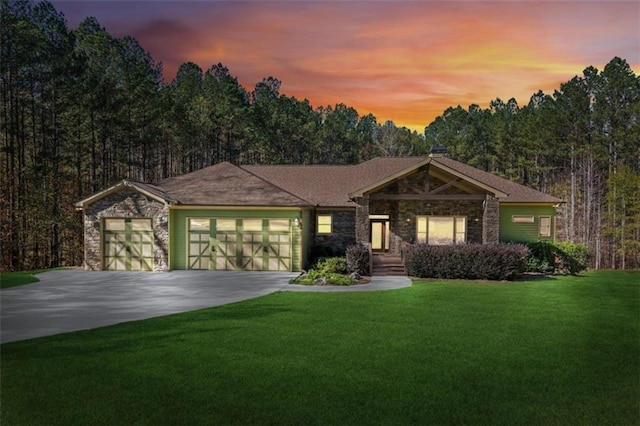 view of front of home with a garage and a lawn