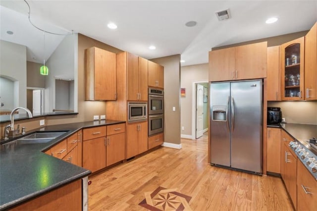 kitchen featuring light hardwood / wood-style floors, sink, stainless steel appliances, and vaulted ceiling