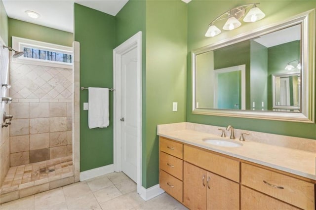 bathroom with tile patterned floors, vanity, and a tile shower