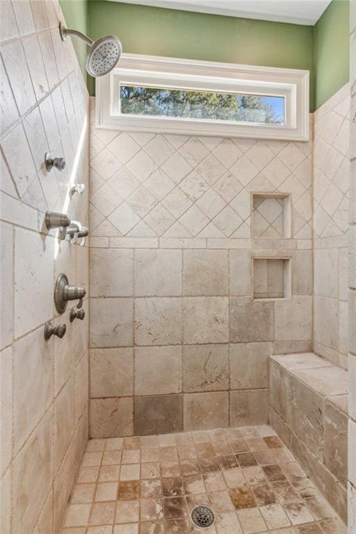 bathroom with a tile shower and a wealth of natural light