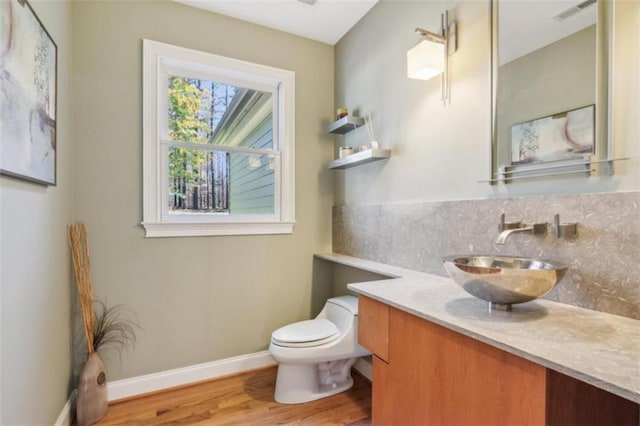 bathroom featuring vanity, wood-type flooring, and toilet