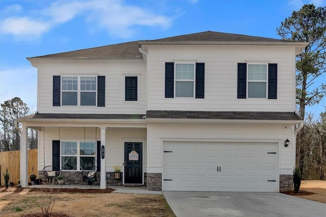 craftsman-style home with stone siding, covered porch, driveway, and a garage