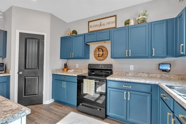 kitchen featuring blue cabinets and black range with electric stovetop