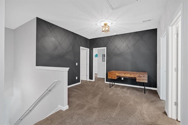 interior space featuring visible vents, an upstairs landing, baseboards, and carpet flooring