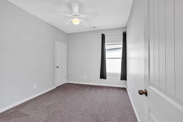 empty room with visible vents, a ceiling fan, baseboards, and dark carpet