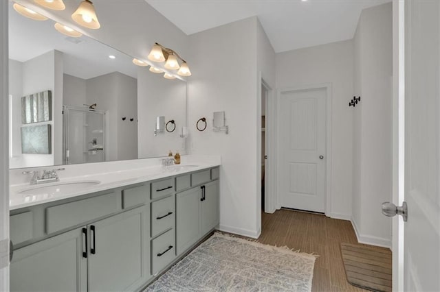 bathroom featuring baseboards, a stall shower, and a sink