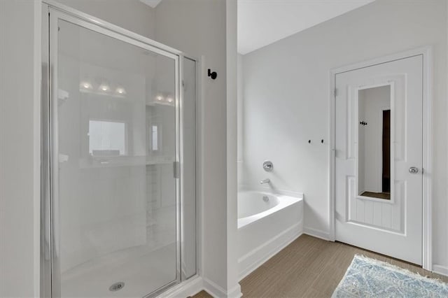 full bathroom featuring a garden tub, baseboards, and a stall shower