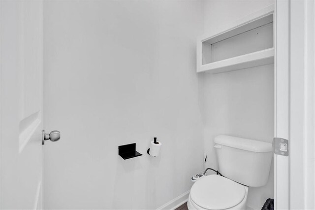 bathroom with toilet and baseboards