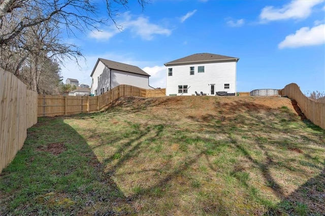 back of property with a lawn and a fenced backyard