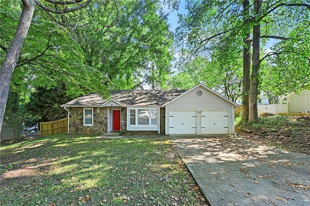 view of front of property with an attached garage, fence, stone siding, driveway, and a front lawn