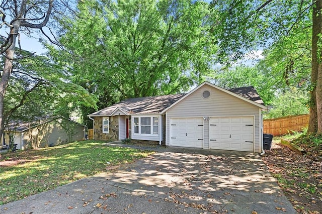 ranch-style home with concrete driveway, a front yard, fence, a garage, and stone siding