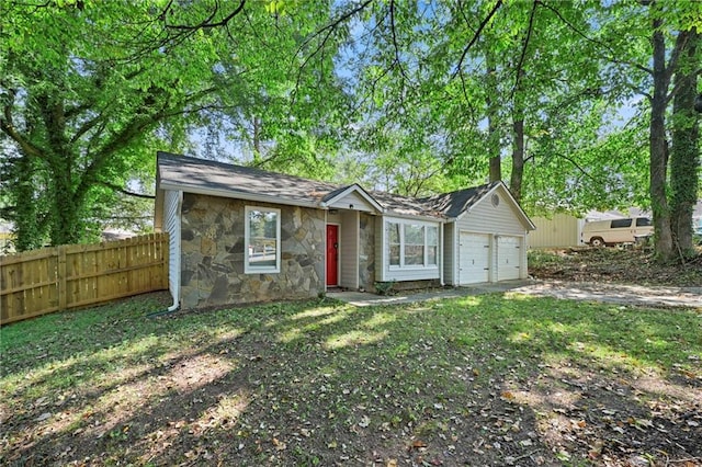 view of front of house featuring a garage, stone siding, fence, and driveway