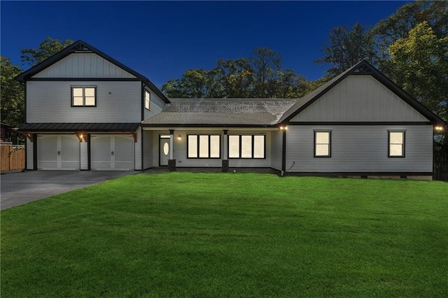 modern inspired farmhouse featuring a garage and a lawn