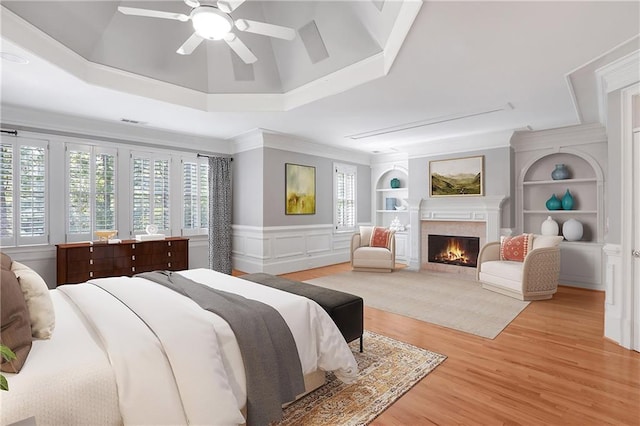 5040 Harrington Rd, Johns Creek, GA 30022 - bedroom with a warm lit fireplace, light wood-style flooring, ceiling fan, a wainscoted wall, and ornamental molding