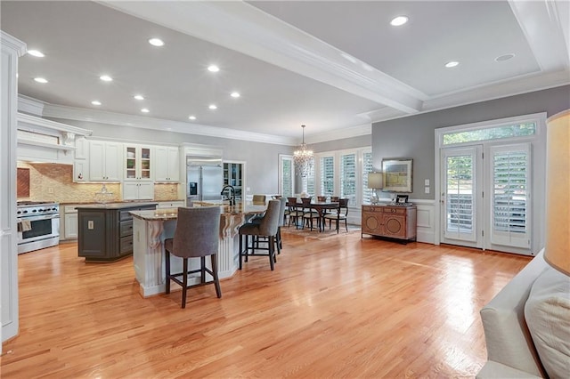 5040 Harrington Rd, Johns Creek, GA 30022 - kitchen featuring high quality appliances, an island with sink, a chandelier, a kitchen breakfast bar, and ornamental molding