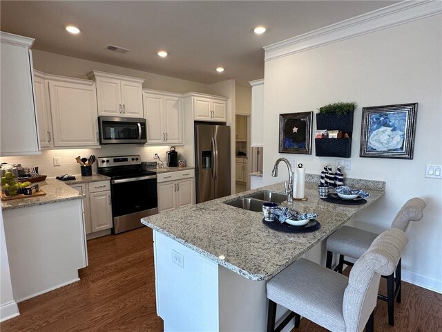 1802 Bonica Xing Unit 1802, Cumming, GA 30040 - kitchen with dark wood finished floors, visible vents, a sink, a kitchen breakfast bar, and appliances with stainless steel finishes