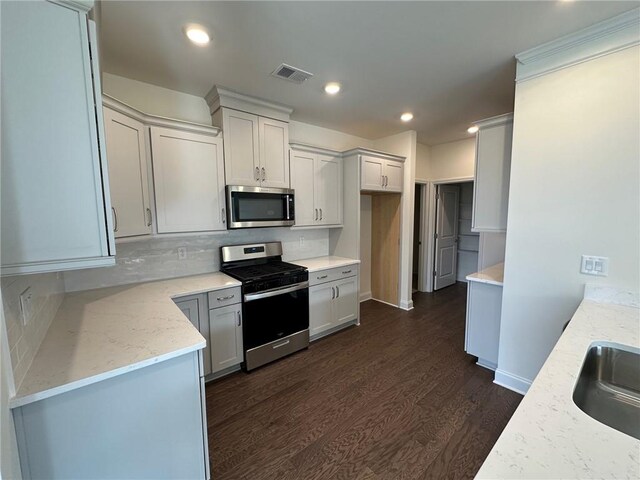 1802 Bonica Xing Unit 1802, Cumming, GA 30040 - kitchen with appliances with stainless steel finishes, visible vents, tasteful backsplash, and dark wood-type flooring