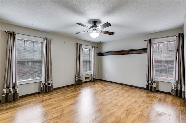 unfurnished room with ceiling fan, a healthy amount of sunlight, a textured ceiling, and light hardwood / wood-style floors