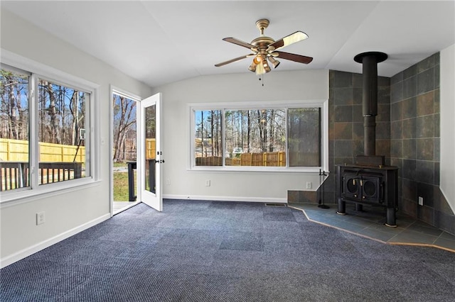 1833 Lost Mountain Rd, Powder Springs, GA 30127 - unfurnished living room featuring a ceiling fan, baseboards, a wood stove, vaulted ceiling, and carpet flooring