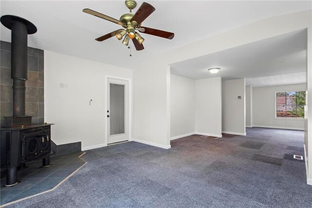 1833 Lost Mountain Rd, Powder Springs, GA 30127 - unfurnished living room with carpet flooring, baseboards, a wood stove, and a ceiling fan