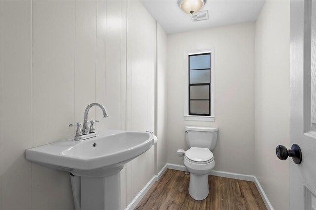 1833 Lost Mountain Rd, Powder Springs, GA 30127 - bathroom featuring wood finished floors, visible vents, baseboards, a sink, and toilet