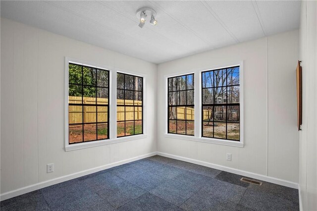 1833 Lost Mountain Rd, Powder Springs, GA 30127 - unfurnished room featuring visible vents, plenty of natural light, baseboards, and dark colored carpet
