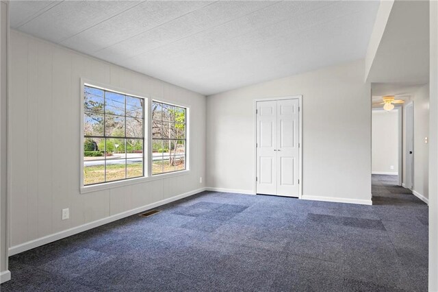 1833 Lost Mountain Rd, Powder Springs, GA 30127 - unfurnished bedroom featuring vaulted ceiling, visible vents, dark colored carpet, and baseboards