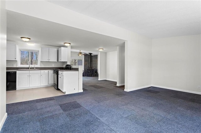 1833 Lost Mountain Rd, Powder Springs, GA 30127 - kitchen with black appliances, a sink, dark countertops, open floor plan, and light colored carpet