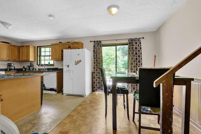 504 Rock Meadow Dr, Stone Mountain, GA 30088 - kitchen with white appliances, a textured ceiling, dark countertops, and brown cabinets