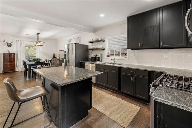 kitchen with a center island, a kitchen breakfast bar, light stone counters, dark hardwood / wood-style flooring, and appliances with stainless steel finishes