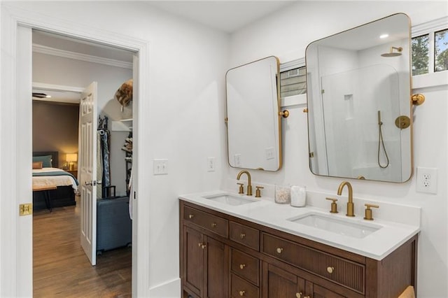 bathroom featuring hardwood / wood-style floors, vanity, walk in shower, and crown molding