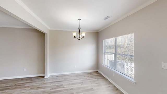 spare room with light wood finished floors, baseboards, visible vents, crown molding, and a chandelier