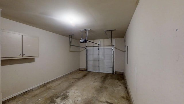 garage with baseboards and a garage door opener