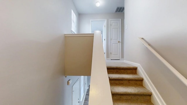 staircase with carpet, visible vents, and baseboards