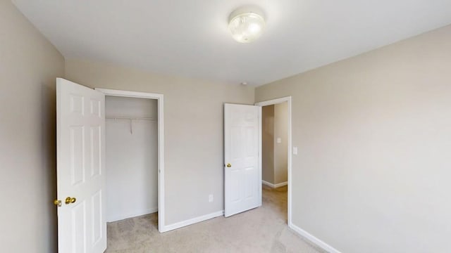 unfurnished bedroom with baseboards, a closet, and light colored carpet