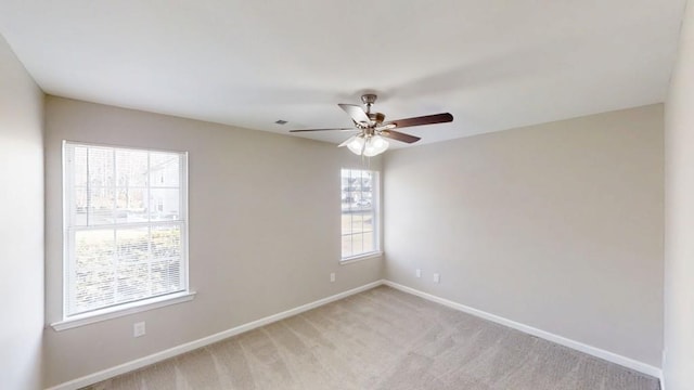 unfurnished room with light colored carpet, ceiling fan, and baseboards