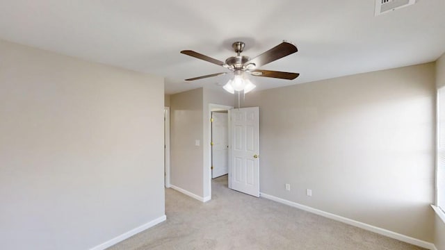 unfurnished bedroom with a ceiling fan, visible vents, light carpet, and baseboards