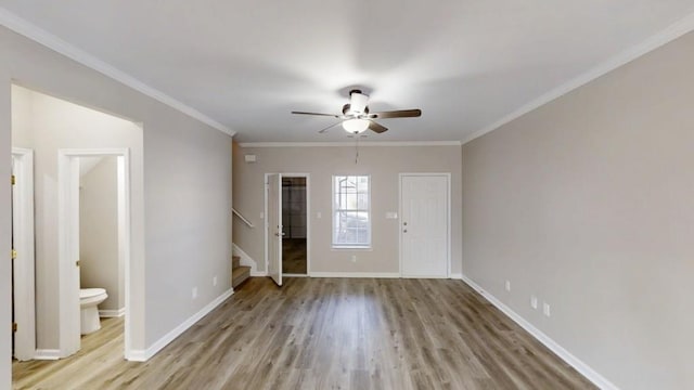 interior space featuring light wood-type flooring, crown molding, baseboards, and stairs