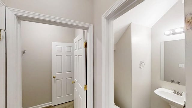 bathroom featuring lofted ceiling, a sink, and toilet