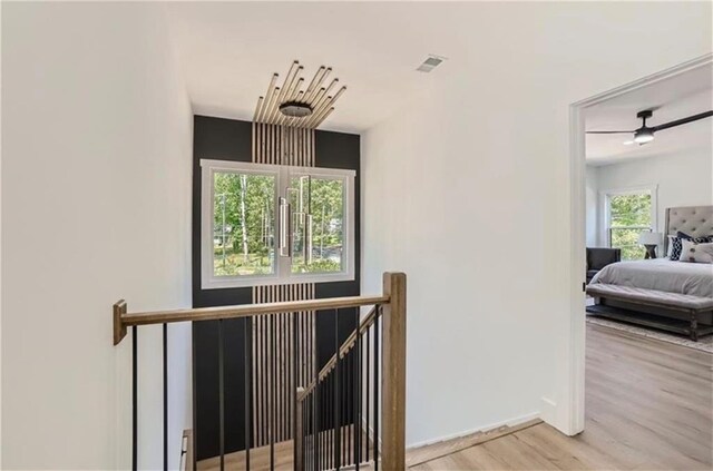 staircase with ceiling fan and wood-type flooring