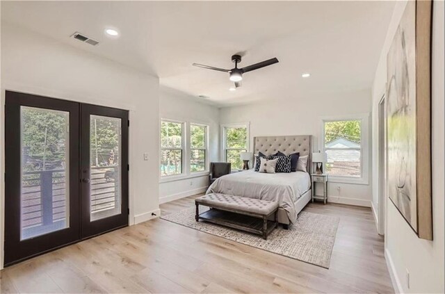 bedroom featuring light wood-type flooring, access to outside, multiple windows, and ceiling fan