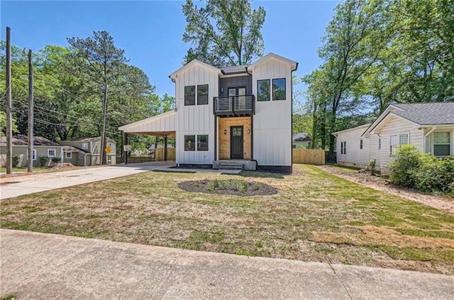 view of front of home with a carport, a balcony, and a front yard