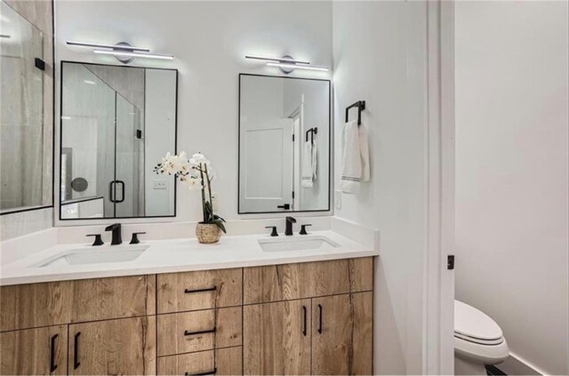 bathroom with an enclosed shower, vanity, and toilet