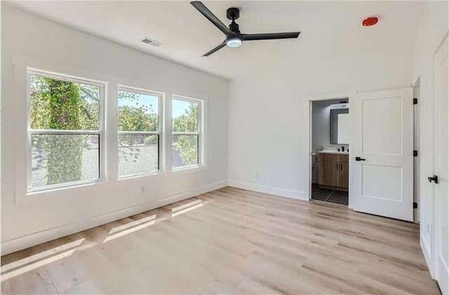 unfurnished bedroom featuring ensuite bathroom, light hardwood / wood-style flooring, and ceiling fan