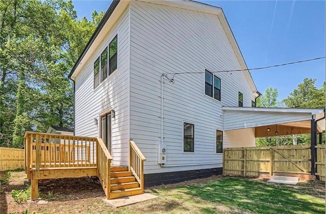 back of property featuring a wooden deck and a yard