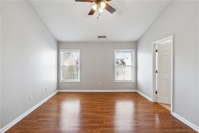 unfurnished room featuring lofted ceiling, visible vents, plenty of natural light, and wood finished floors