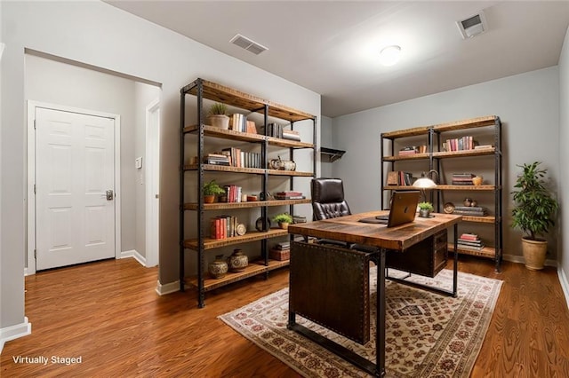 office space featuring visible vents, baseboards, and wood finished floors