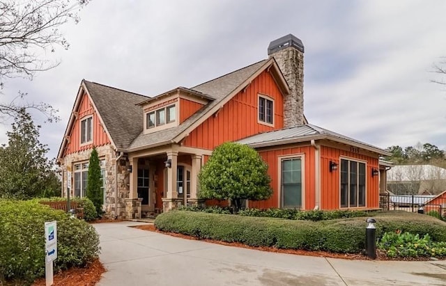 view of front of home featuring a chimney, board and batten siding, and roof with shingles